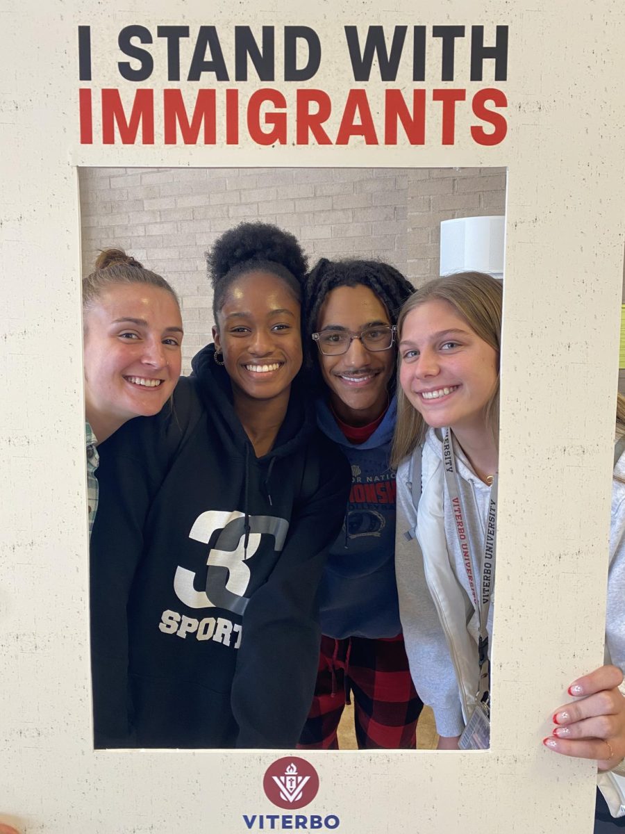 Students holding the “I Stand With Immigrants” sign 